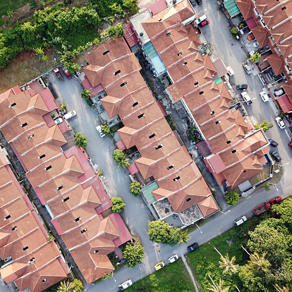 drilldown-capabilities an arial photo of a housing complex with cars parked around the property and trees lining the edges